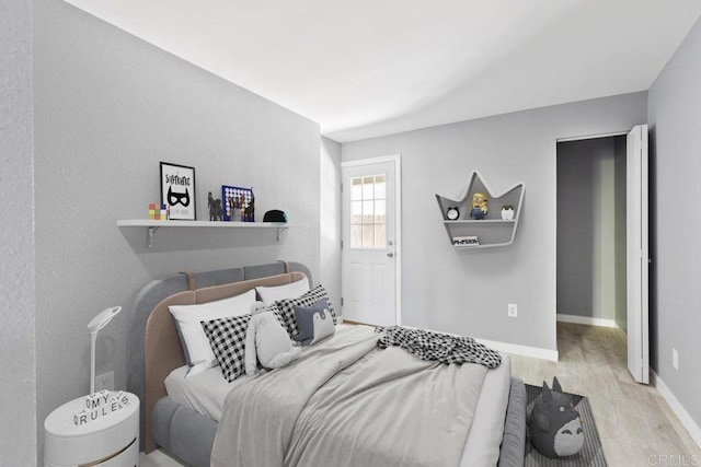 bedroom with baseboards and wood finished floors