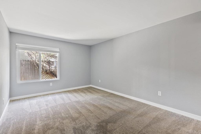 carpeted empty room with baseboards