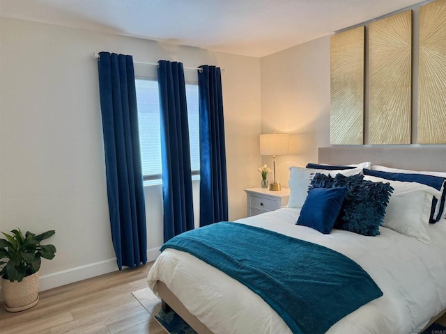 bedroom with baseboards and light wood finished floors