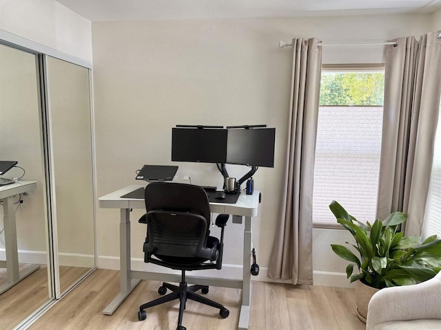 home office with baseboards and wood finished floors