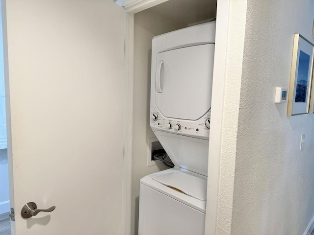 laundry room featuring stacked washer / drying machine and laundry area
