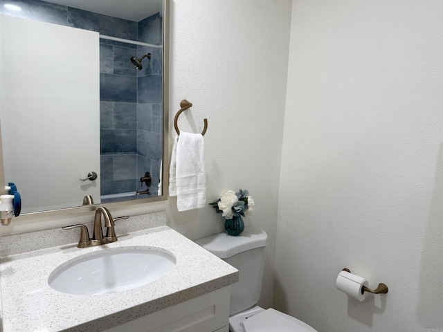 bathroom with vanity, walk in shower, and toilet