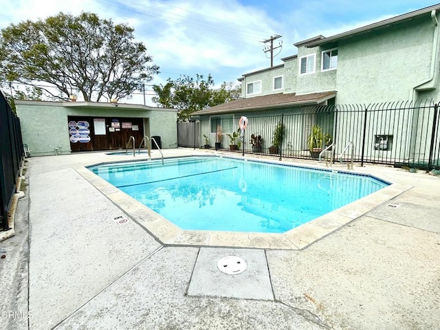 community pool featuring a patio area and fence