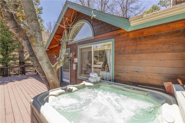 wooden deck with an outdoor hot tub