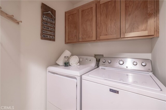 clothes washing area with cabinet space and washer and clothes dryer
