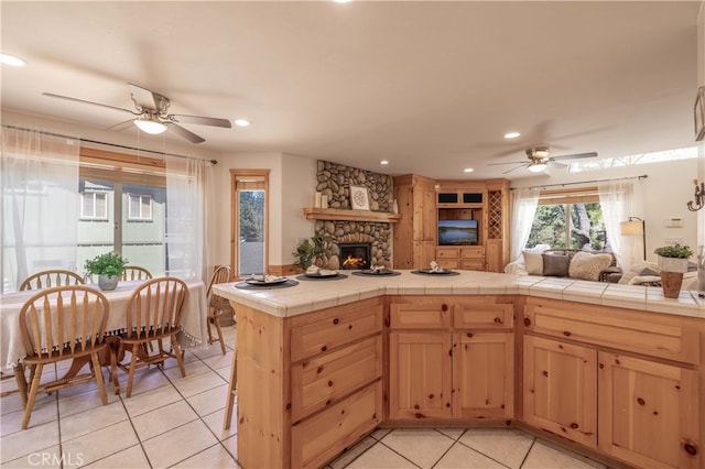 kitchen featuring open floor plan, ceiling fan, and light tile patterned floors