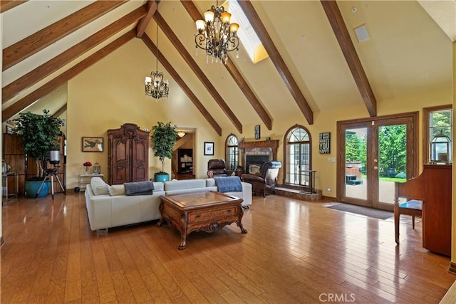 1031 Black Oaks Dr, Lake Arrowhead, CA 92352 - living area with a chandelier, beamed ceiling, high vaulted ceiling, a glass covered fireplace, and wood-type flooring