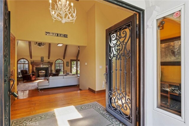 1031 Black Oaks Dr, Lake Arrowhead, CA 92352 - foyer with wood finished floors, a chandelier, a high end fireplace, high vaulted ceiling, and beamed ceiling