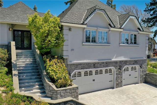 1031 Black Oaks Dr, Lake Arrowhead, CA 92352 - view of front of property featuring stucco siding, french doors, an attached garage, stairway, and driveway