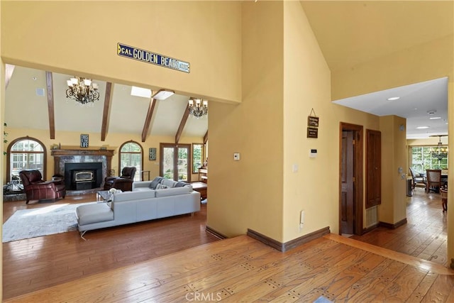 1031 Black Oaks Dr, Lake Arrowhead, CA 92352 - living room featuring high vaulted ceiling, a chandelier, hardwood / wood-style floors, a glass covered fireplace, and beam ceiling