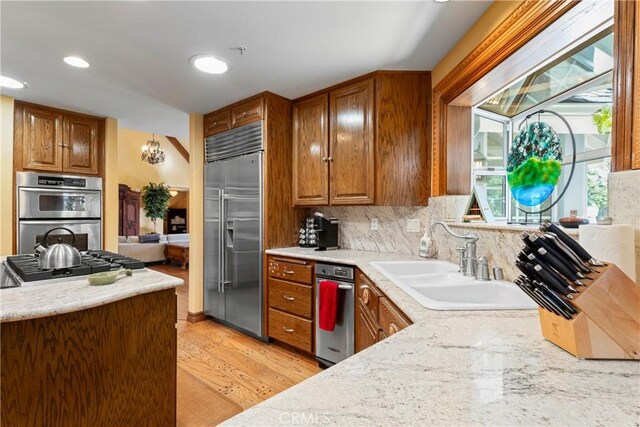 1031 Black Oaks Dr, Lake Arrowhead, CA 92352 - kitchen featuring stainless steel appliances, brown cabinets, light wood-style flooring, decorative backsplash, and recessed lighting