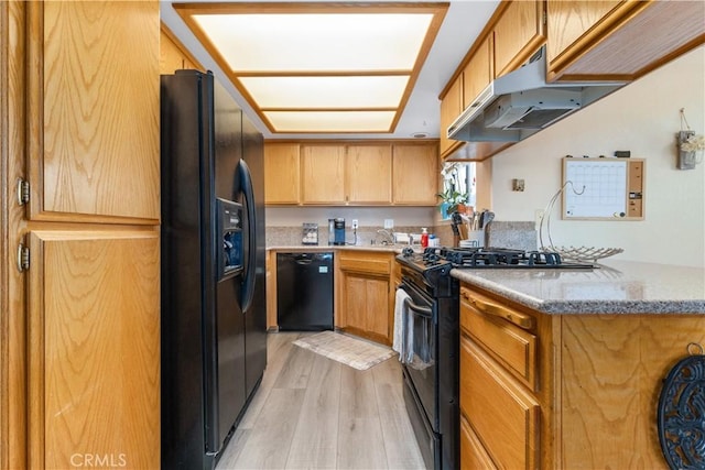 9375 Musselman Dr Unit A, Atascadero, CA 93422 - kitchen featuring light stone countertops, light wood-type flooring, a sink, black appliances, and under cabinet range hood