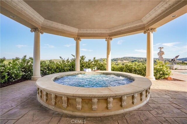 view of patio featuring an in ground hot tub