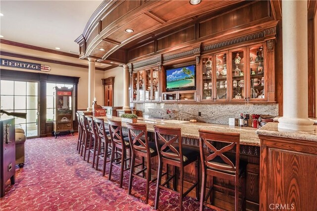 bar featuring ornamental molding, indoor wet bar, decorative columns, and recessed lighting