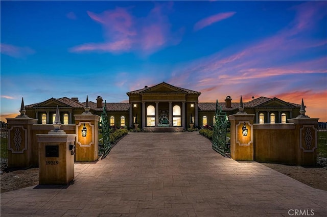 mediterranean / spanish-style house with a gate and fence private yard