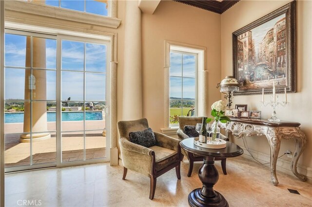 sitting room with tile patterned flooring and ornamental molding