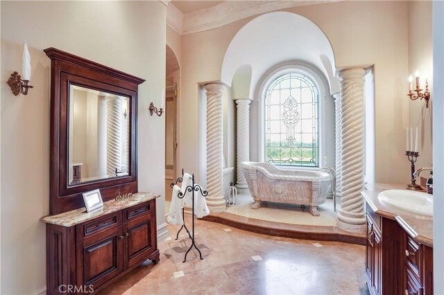 full bath featuring ornate columns, a washtub, and vanity