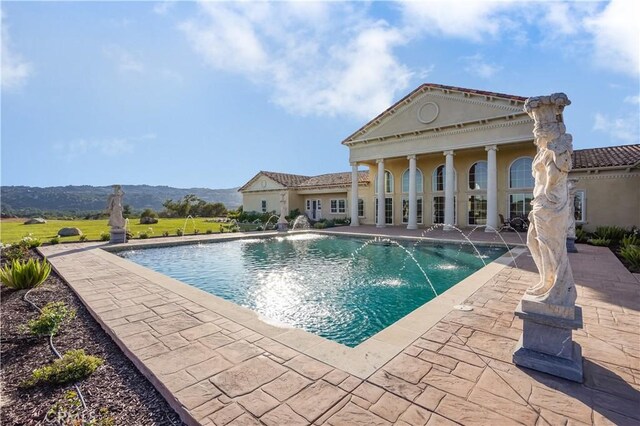 pool featuring a patio and a mountain view