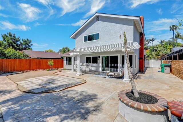 rear view of property with a pergola, a patio, a fenced backyard, and stucco siding