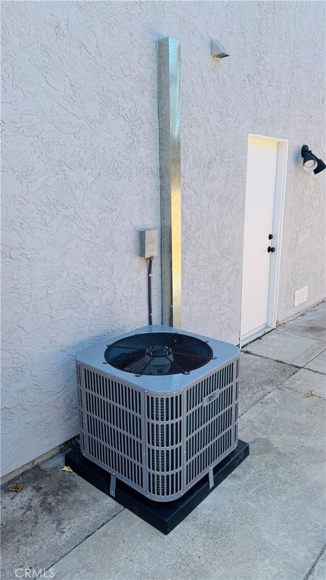 exterior details featuring central AC unit and stucco siding