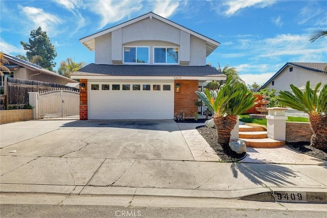 traditional-style home with concrete driveway, an attached garage, a gate, and stucco siding