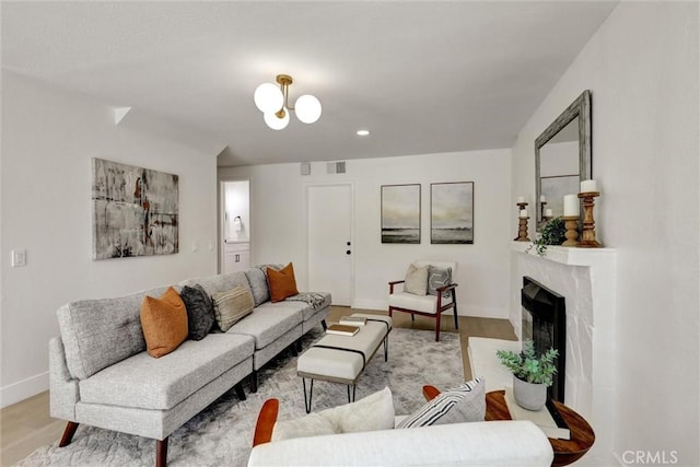 living area with visible vents, a fireplace, baseboards, recessed lighting, and light wood finished floors