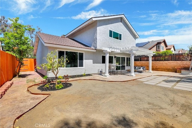 back of property featuring a fenced backyard, a pergola, stucco siding, and a patio area