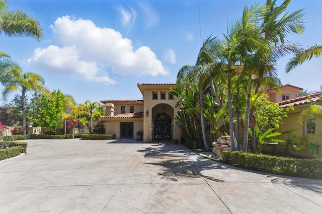 2890 Gate Fifteen Pl, Chula Vista, CA 91914 - mediterranean / spanish house featuring stucco siding, a tiled roof, and curved driveway