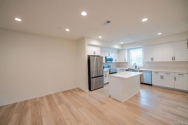 3507 Sequoia St, Lemon Grove, CA 91945 - kitchen featuring light wood-type flooring, light countertops, white cabinetry, a sink, and appliances with stainless steel finishes