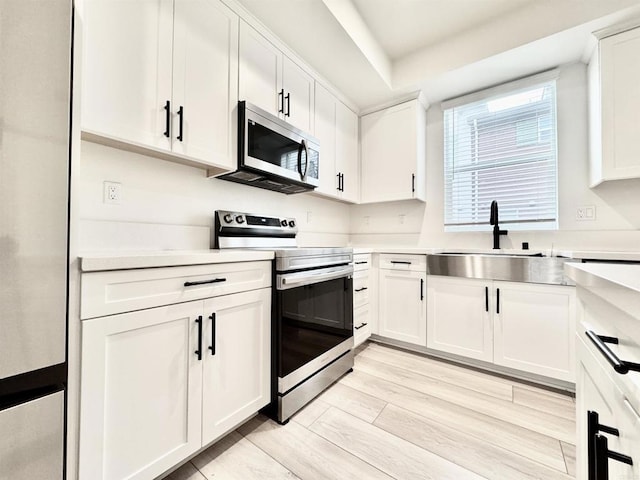3507 Sequoia St, Lemon Grove, CA 91945 - kitchen featuring a sink, white cabinetry, appliances with stainless steel finishes, and light countertops