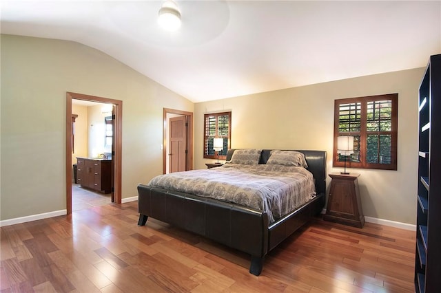 bedroom with light wood-style floors, baseboards, vaulted ceiling, and multiple windows