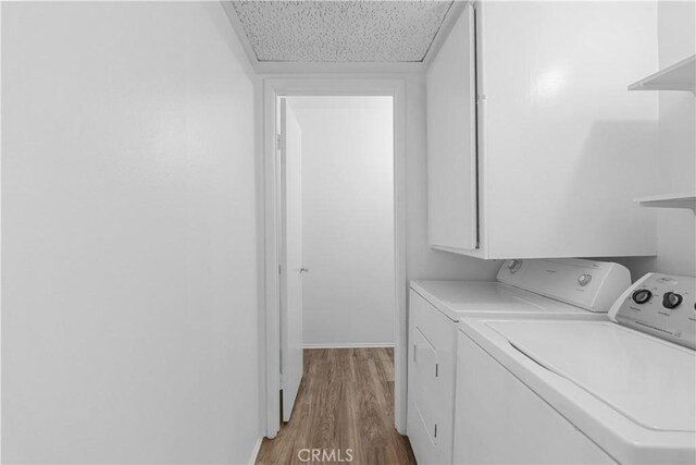 laundry area featuring laundry area, washing machine and dryer, and light wood-style flooring
