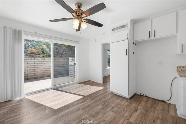 interior space with visible vents, a ceiling fan, plenty of natural light, and wood finished floors
