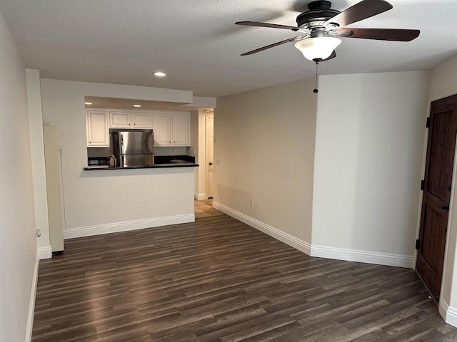 unfurnished living room featuring baseboards, a ceiling fan, dark wood-style floors, and recessed lighting