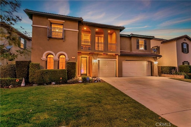 13744 Star Ruby Ave, Eastvale, CA 92880 - mediterranean / spanish home with a balcony, a front yard, stucco siding, an attached garage, and driveway