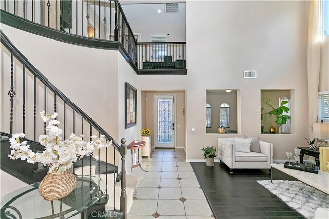 13744 Star Ruby Ave, Eastvale, CA 92880 - foyer featuring stairs, baseboards, visible vents, and a towering ceiling