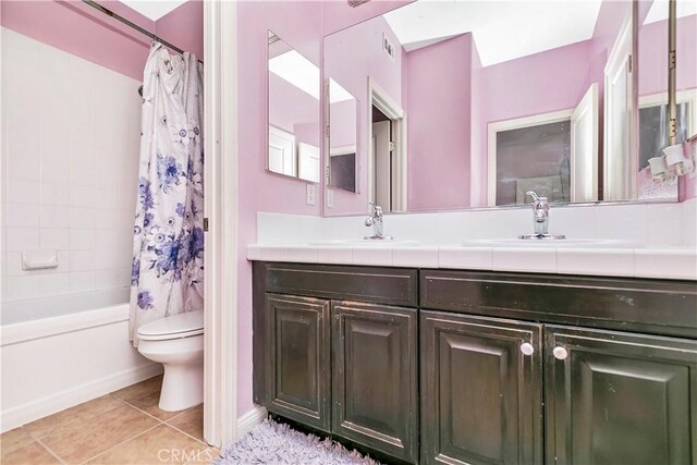 13744 Star Ruby Ave, Eastvale, CA 92880 - bathroom with a sink, double vanity, toilet, tile patterned floors, and shower / bath combo with shower curtain