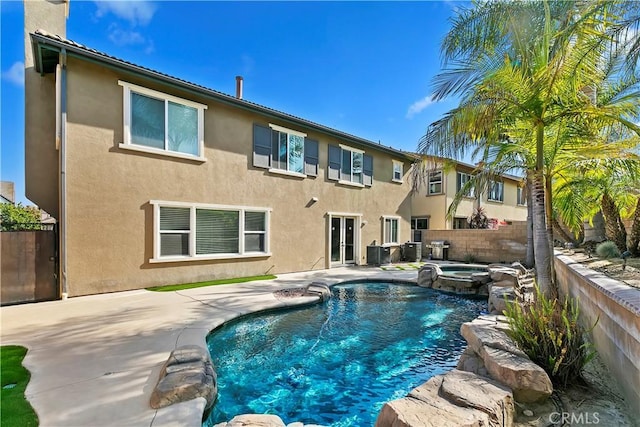 13744 Star Ruby Ave, Eastvale, CA 92880 - back of house featuring stucco siding, a fenced backyard, a fenced in pool, an in ground hot tub, and a patio area
