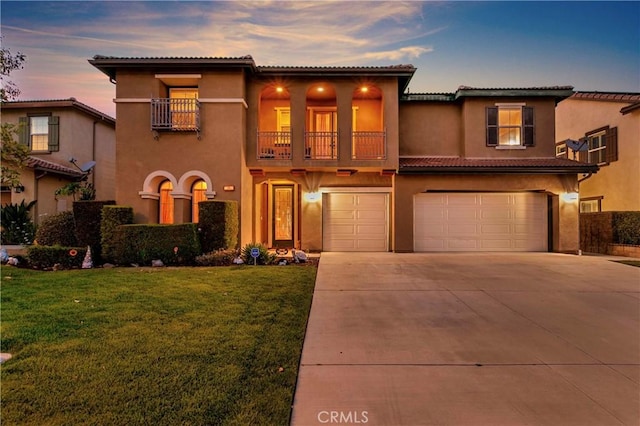 13744 Star Ruby Ave, Eastvale, CA 92880 - mediterranean / spanish-style home featuring a balcony, a front yard, stucco siding, an attached garage, and driveway