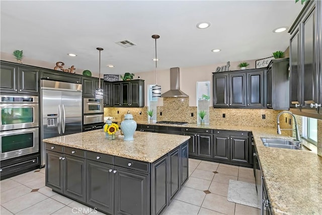 13744 Star Ruby Ave, Eastvale, CA 92880 - kitchen featuring wall chimney range hood, a kitchen island, visible vents, appliances with stainless steel finishes, and a sink