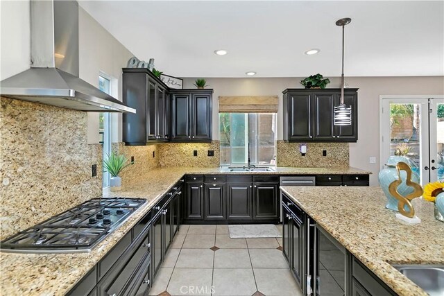 13744 Star Ruby Ave, Eastvale, CA 92880 - kitchen featuring wall chimney range hood, light stone countertops, stainless steel gas cooktop, and light tile patterned floors
