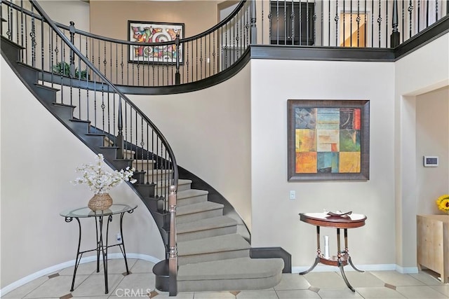 13744 Star Ruby Ave, Eastvale, CA 92880 - stairway with baseboards, tile patterned floors, and a towering ceiling