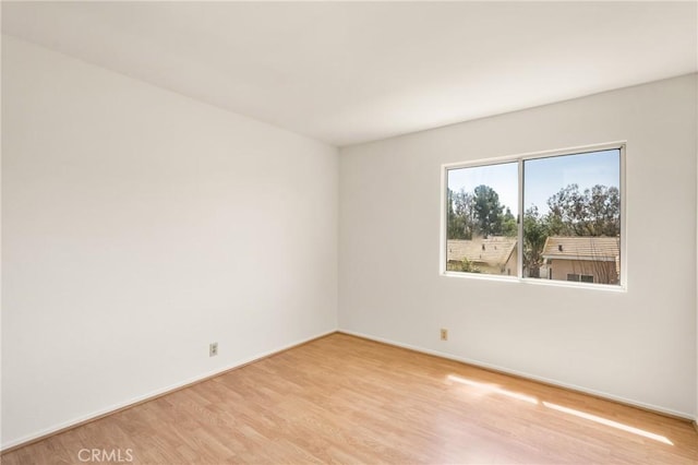 unfurnished room with baseboards and wood finished floors