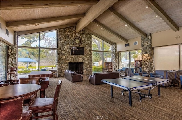 playroom with a stone fireplace, wood ceiling, high vaulted ceiling, and beam ceiling