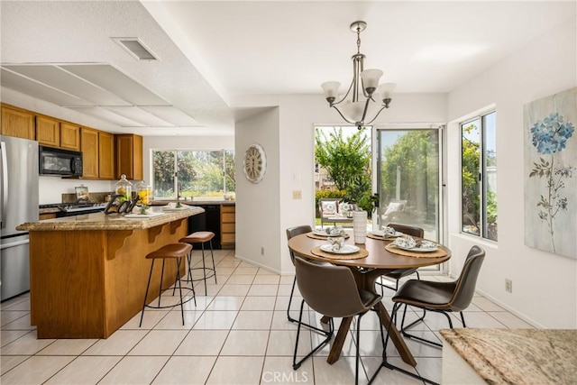 dining area featuring an inviting chandelier, light tile patterned floors, plenty of natural light, and visible vents