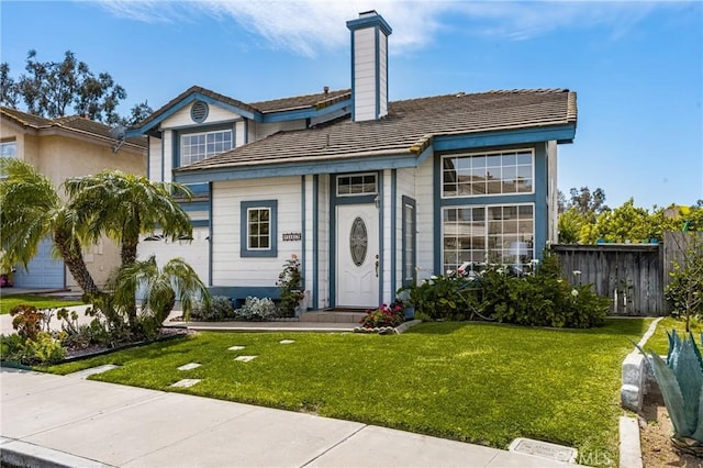 view of front of property featuring a chimney, a front yard, and fence