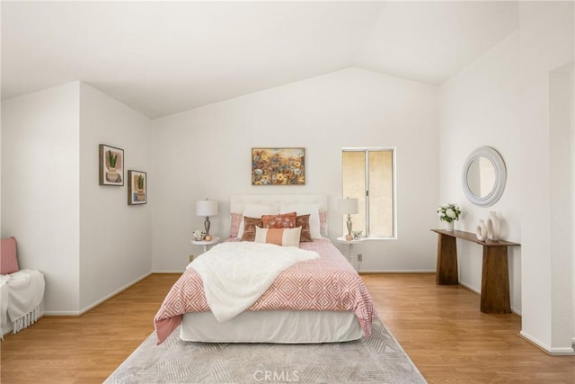 bedroom featuring vaulted ceiling, baseboards, and wood finished floors
