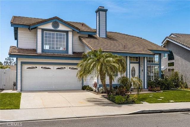 traditional-style house with fence, an attached garage, driveway, a tile roof, and a chimney