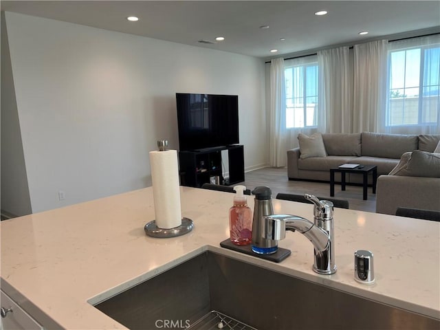 3530 E Delight Paseo Unit 205, Ontario, CA 91761 - kitchen featuring healthy amount of natural light, recessed lighting, open floor plan, a sink, and wood finished floors