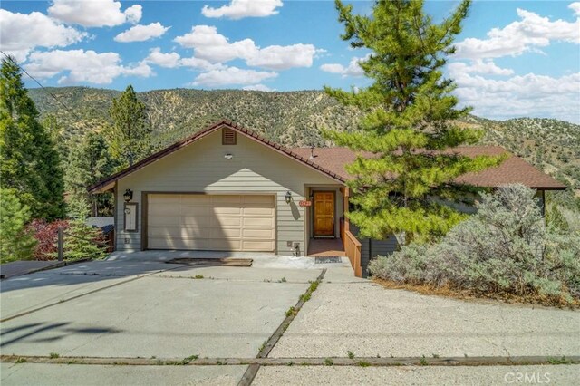 view of front of property featuring concrete driveway, an attached garage, and a mountain view